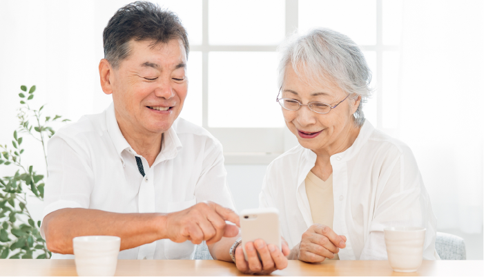 明るい室内でスマホを見るシニア夫婦